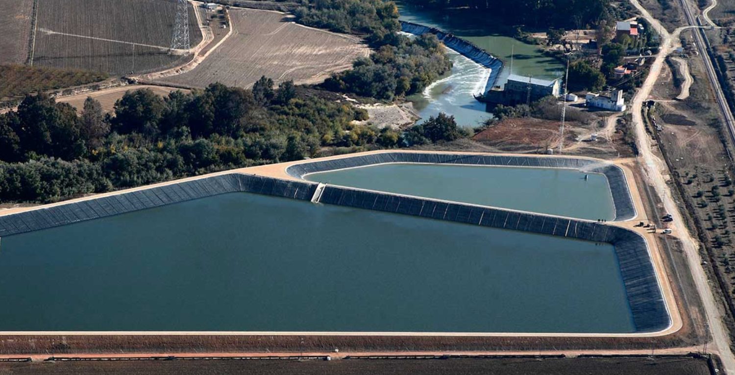 Balsa de regulación e infraestructura de riego junto a olivar